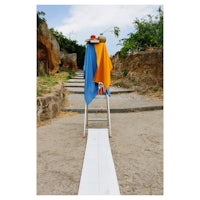 a ladder with towels on it next to a stone wall